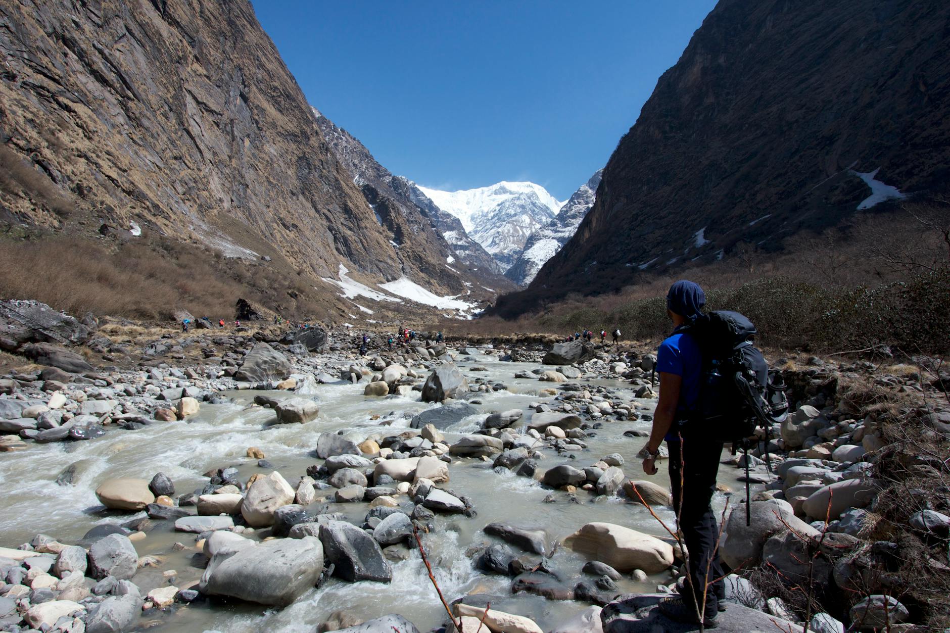 man by the stream in a mountain valley