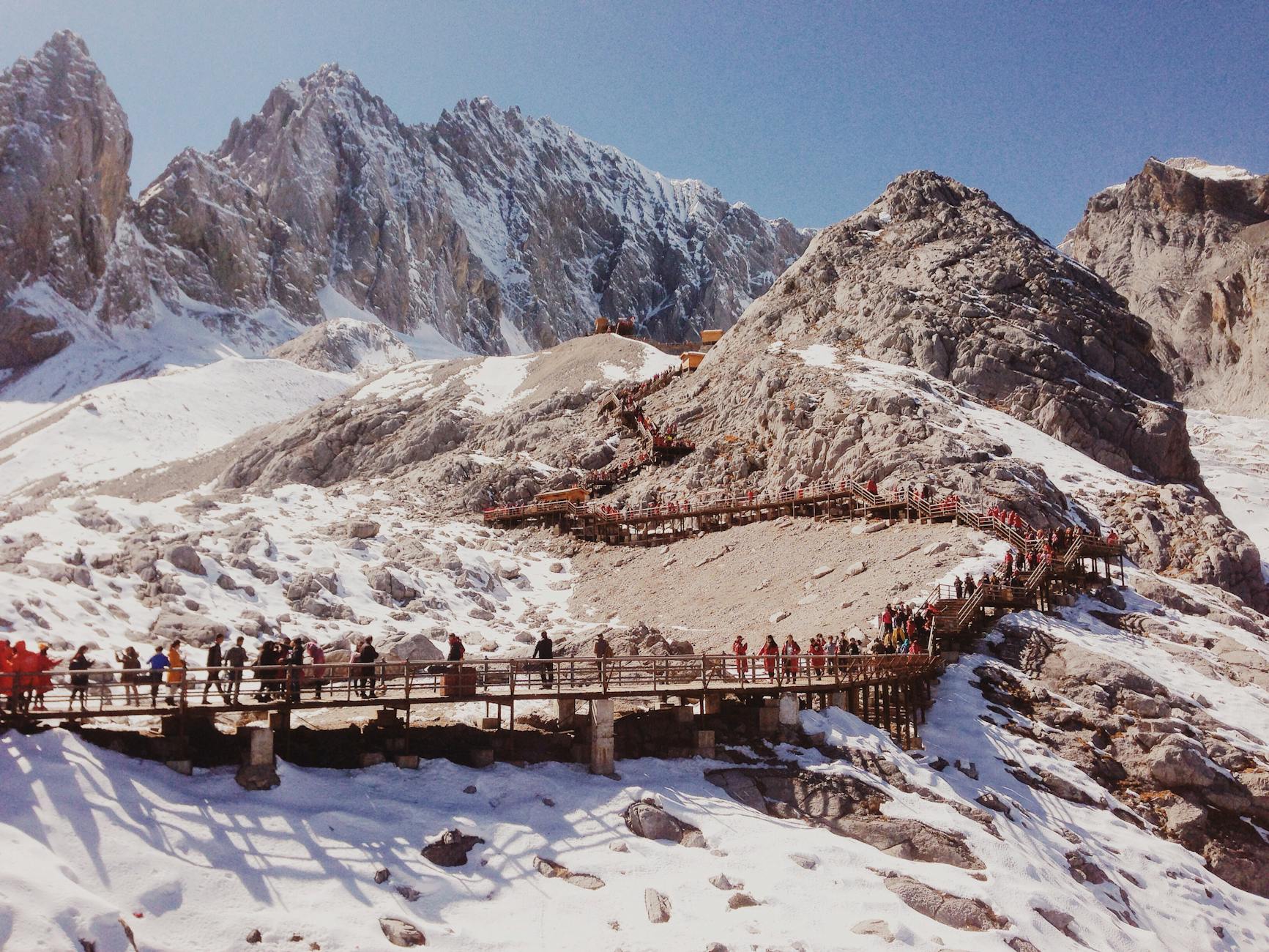 photo of people climbing towards rocky mountain