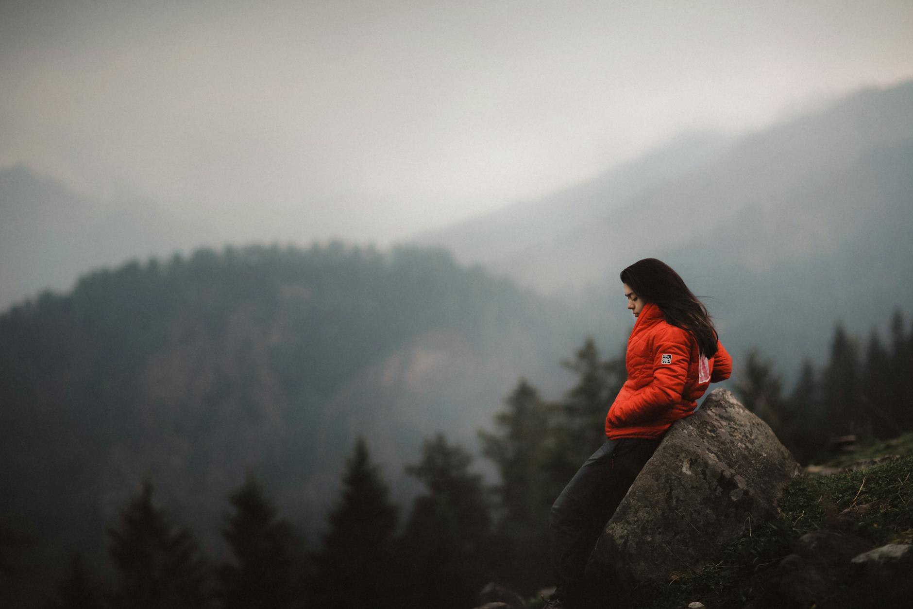 photo of woman leaning on boulder